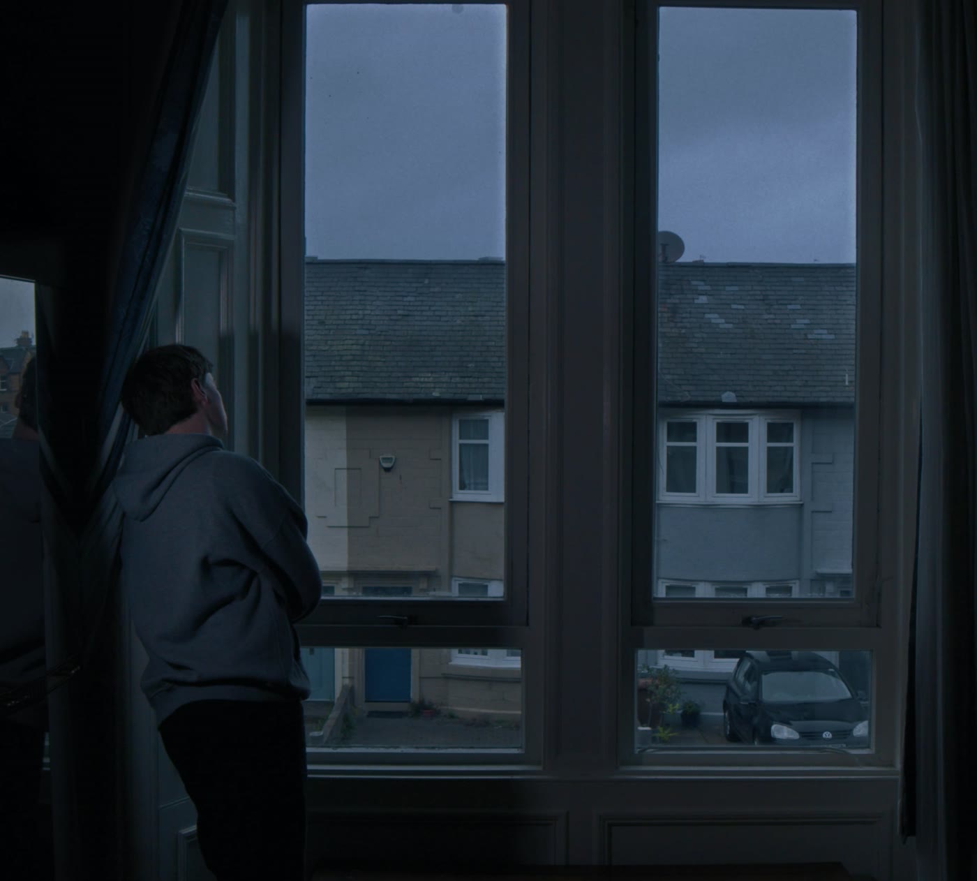 A figure at a window in a dark room